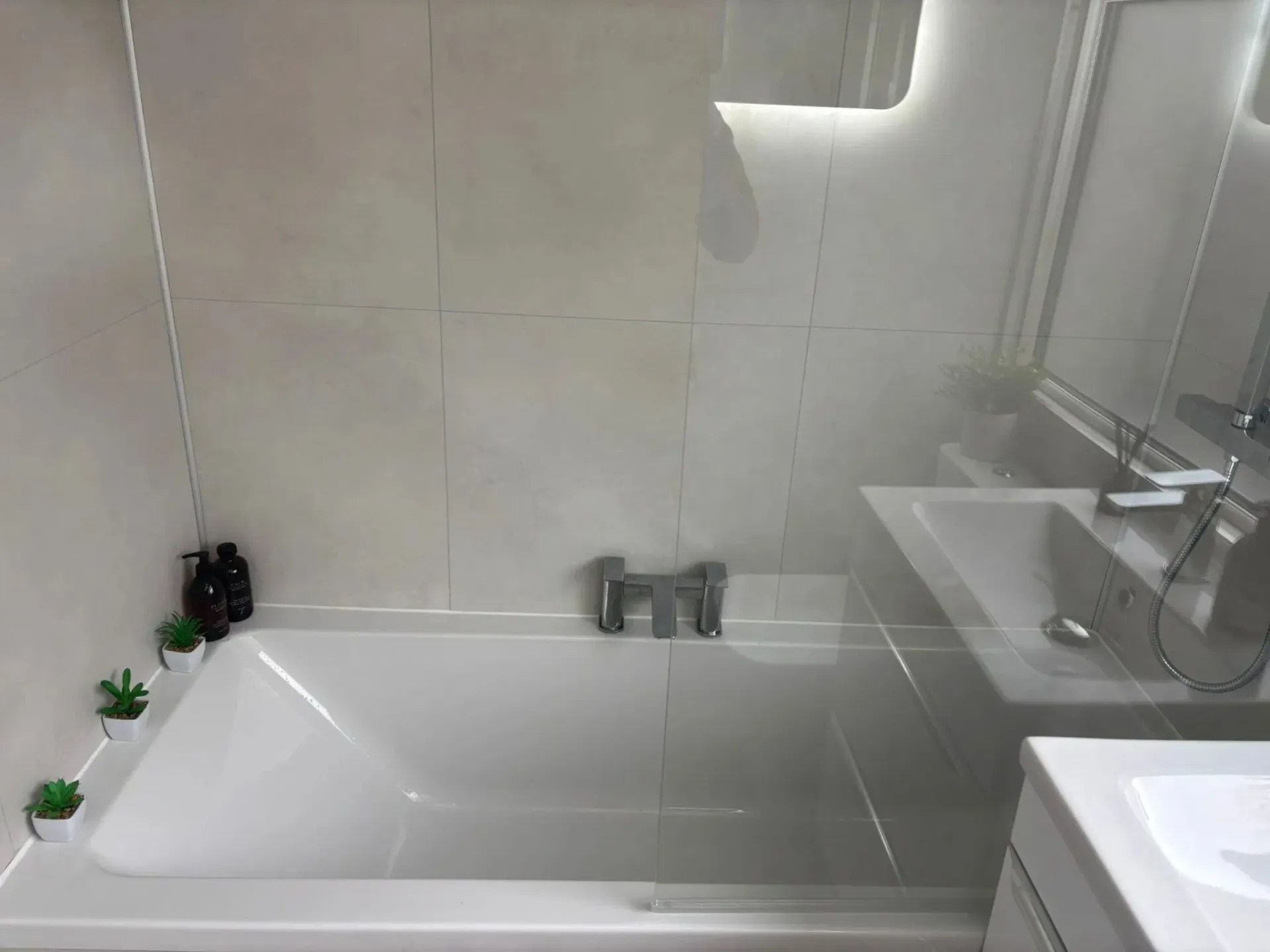 Bright bathroom with a bathtub and glass shower screen